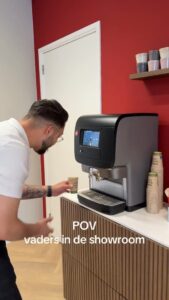 Medewerker van FloorDeals bij de koffiemachine in de showroom